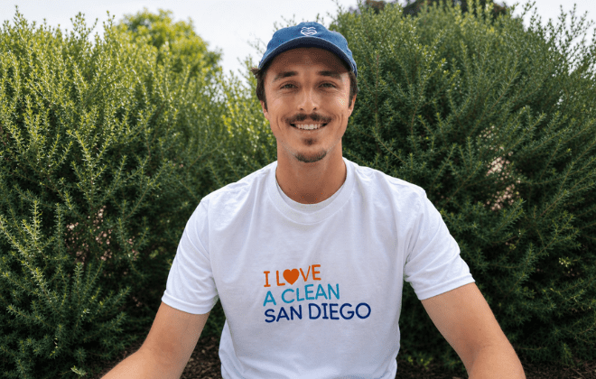 A young man smiles while wearing an I Love A Clean San Diego shirt