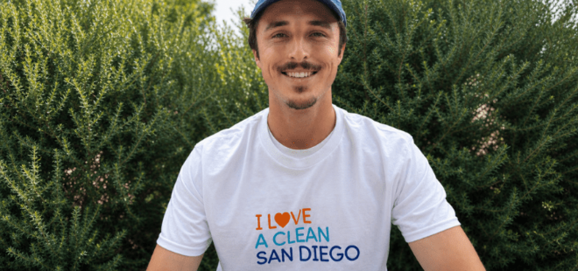 A young man smiles while wearing an I Love A Clean San Diego shirt